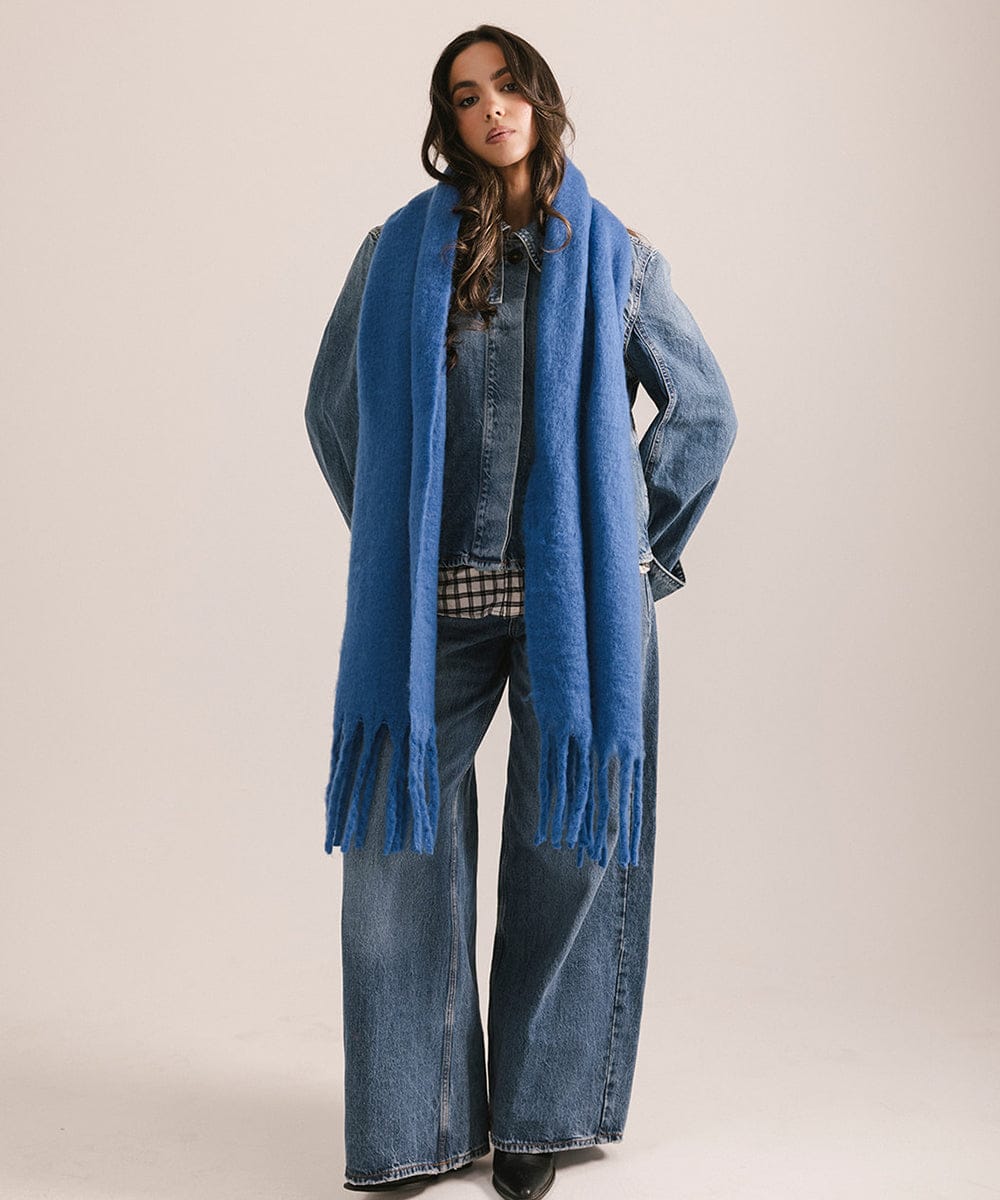 Woman wearing a blue scarf and denim outfit on a plain background #color_alpine blue