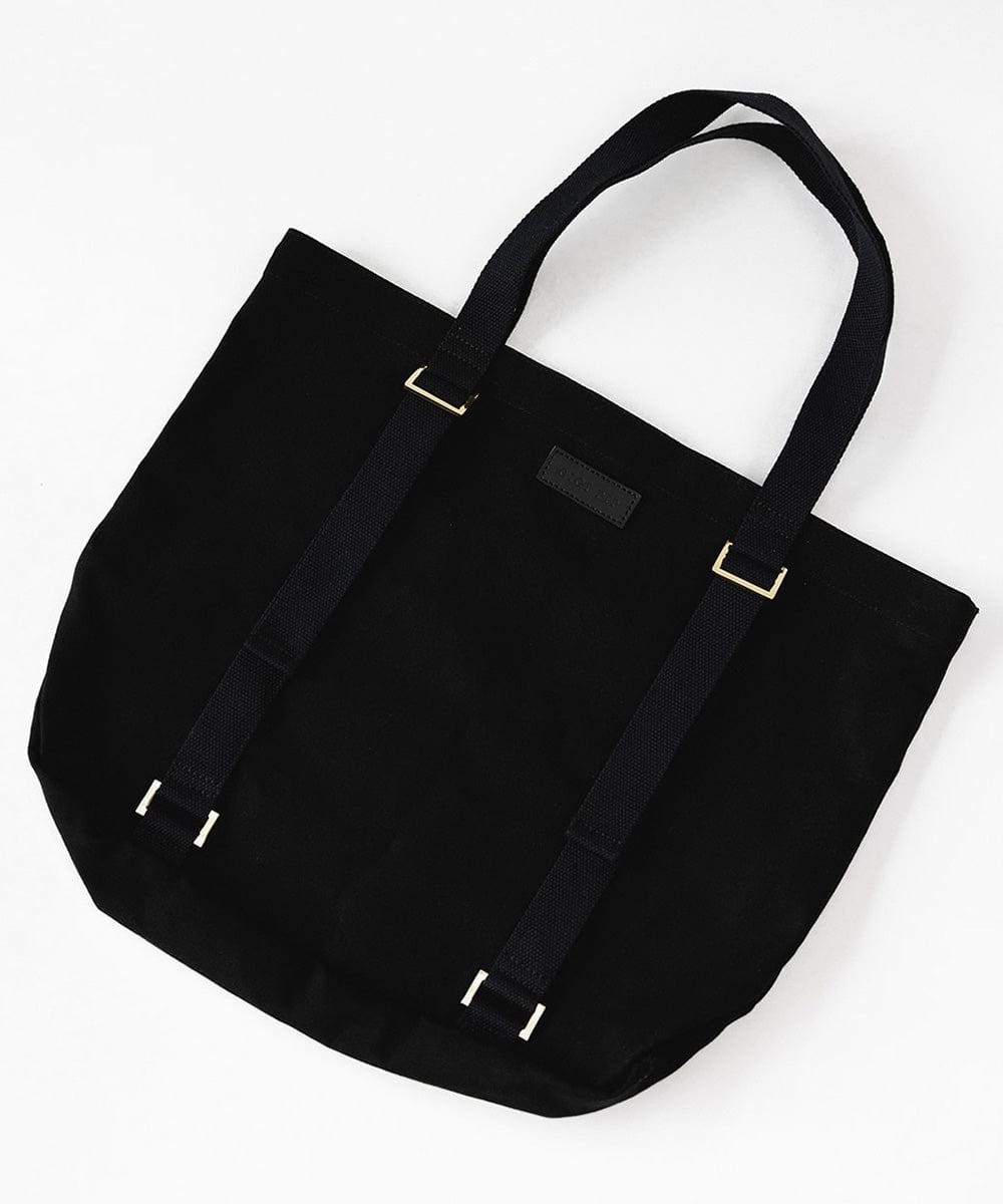 A black canvas tote bag on a plain background with two adjustable straps designed to carry a hat #color_black