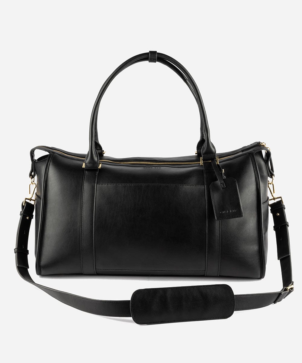 A black vegan leather weekender bag with a detachable shoulder strap and gold-tone hardware against a plain background #color_black