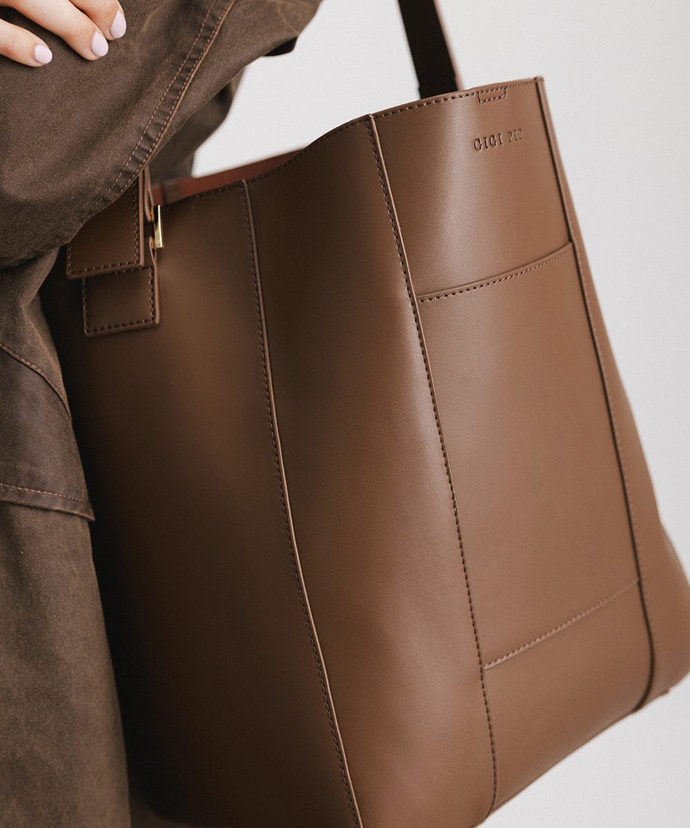 A close up image of a chocolate colored Dia Everyday Leather Tote Bag against a plain background #color_chocolate