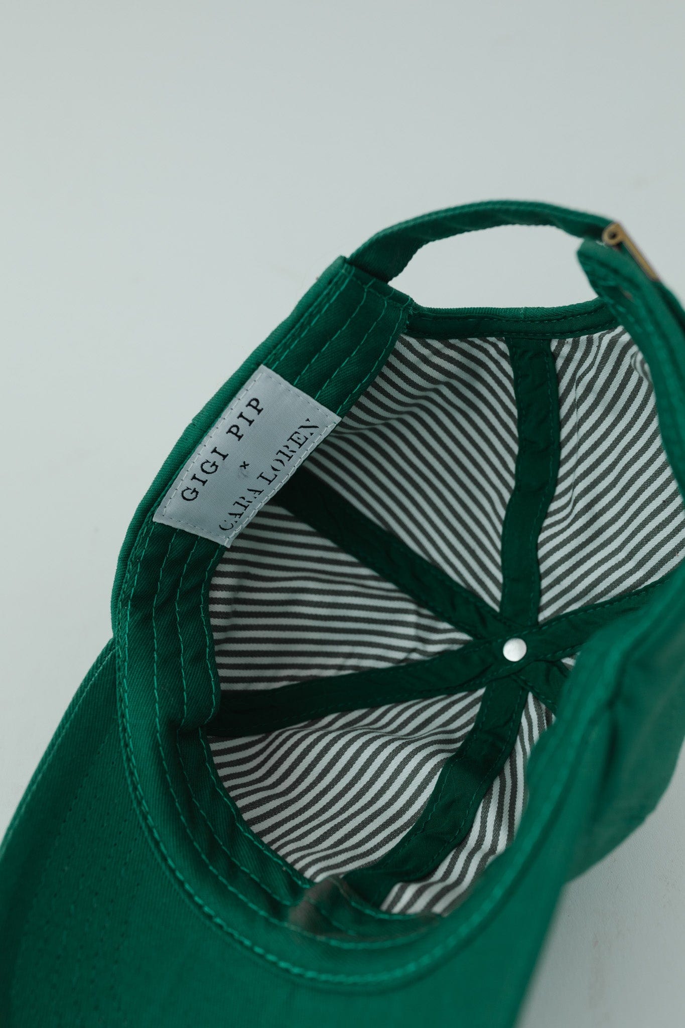 A green ball cap with the brand label, upside down on a plain background #color_green