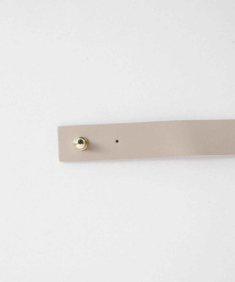 A stone colored leather band with pin on a plain background #color_stone