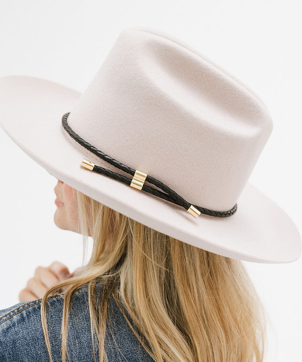 Woman wearing a cream hat with a black braided hat band and a denim shirt, facing sideways against a plain background #color_black