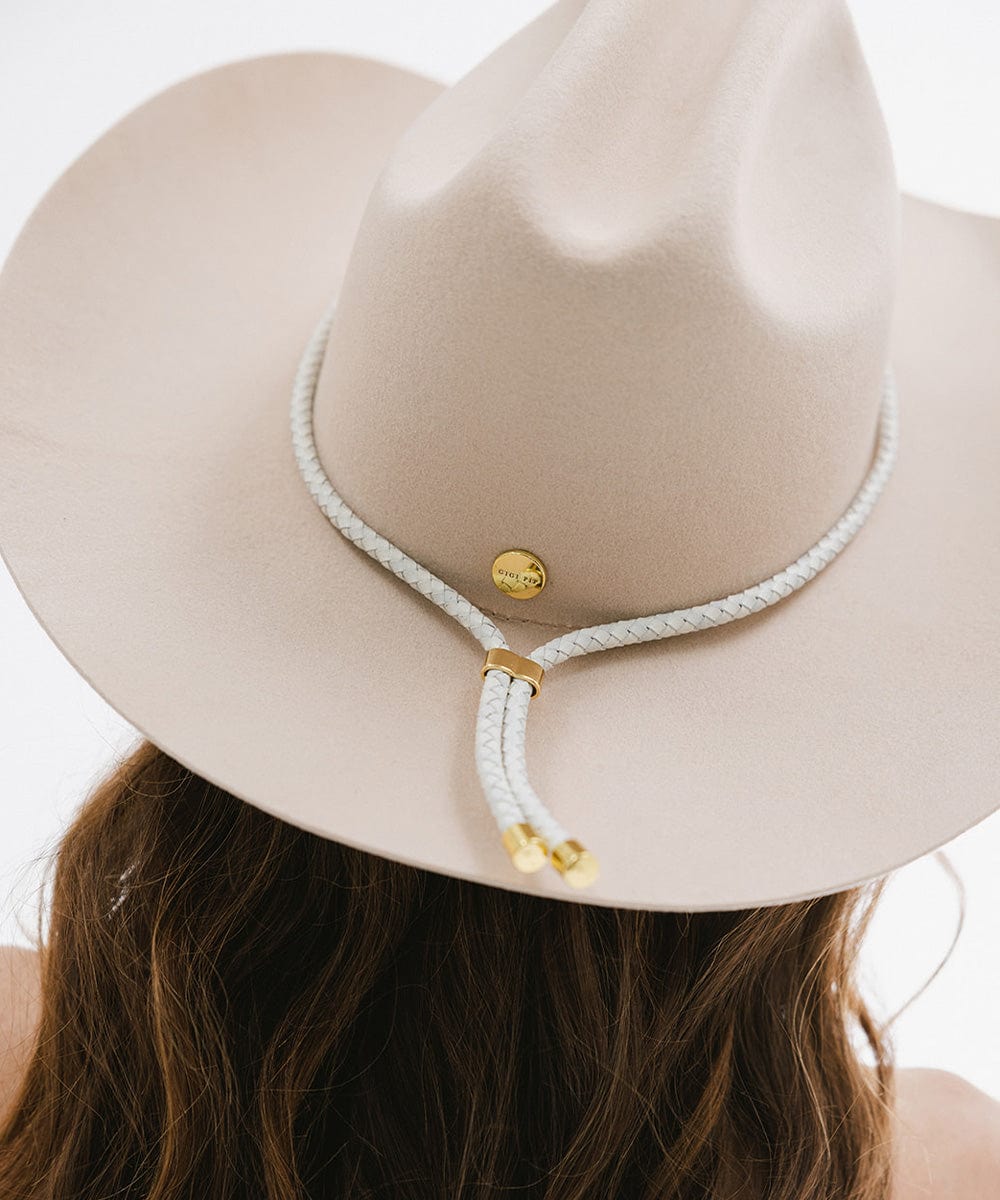 Close up image of a woman wearing a cream hat with an ivory colored braided bolo hat band against a plain background #color_ivory
