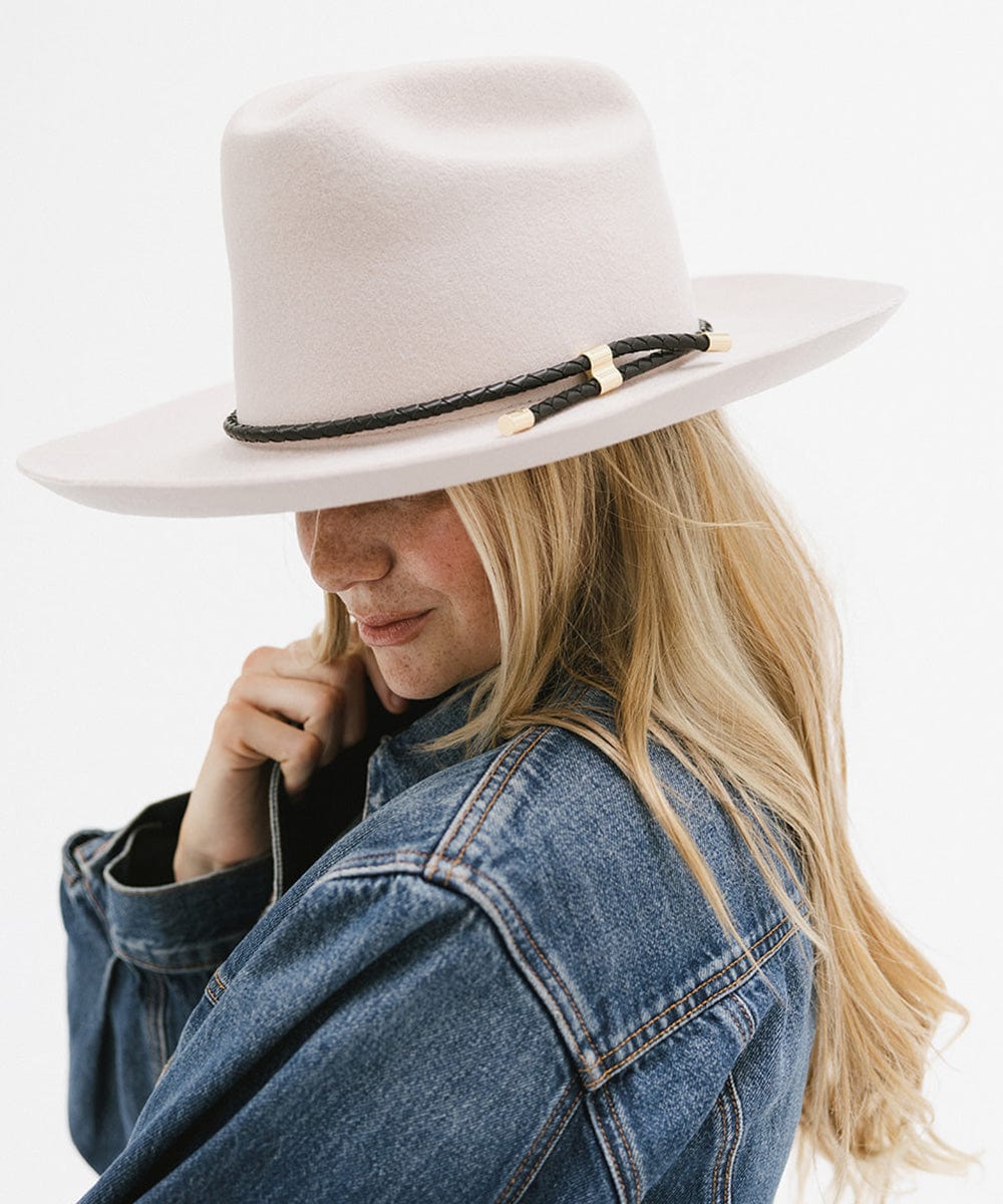 Woman wearing a cream hat with a black braided hat band and a denim shirt, posing sideways against a plain background #color_black