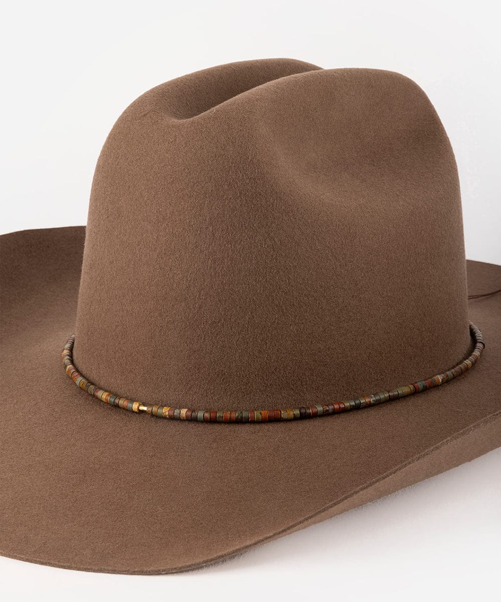 Brown cowboy hat with a beaded band on a white background #color_brown jasper