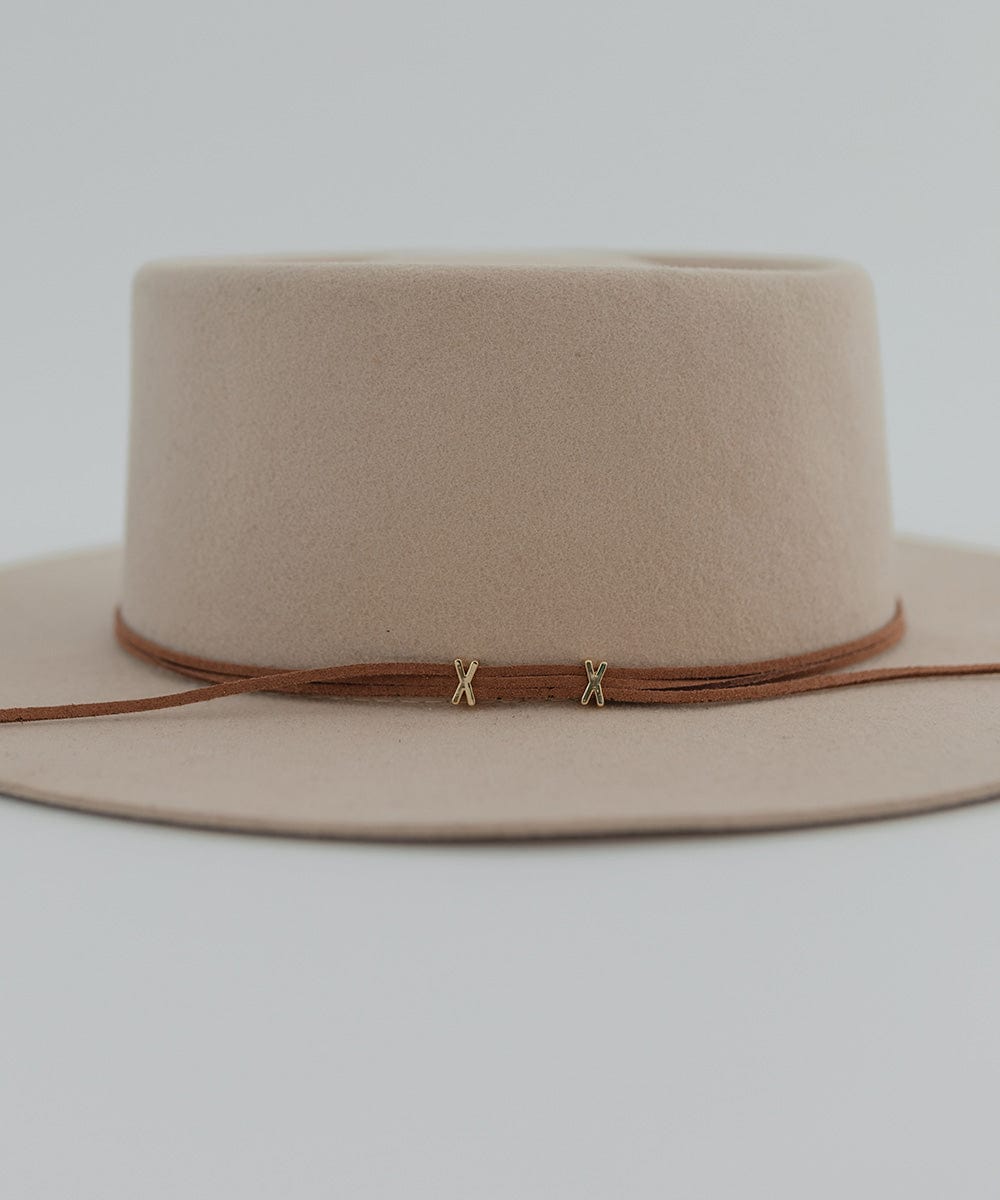 A cream hat with a brown suede xx band on a plain background #color_brown