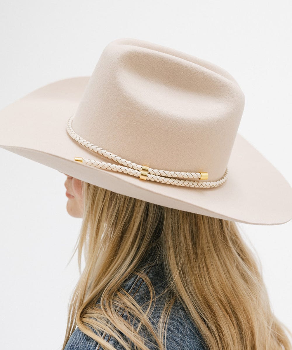 Woman wearing a cream hat with an ivory colored braided hat band facing sideways against a plain background #color_ivory