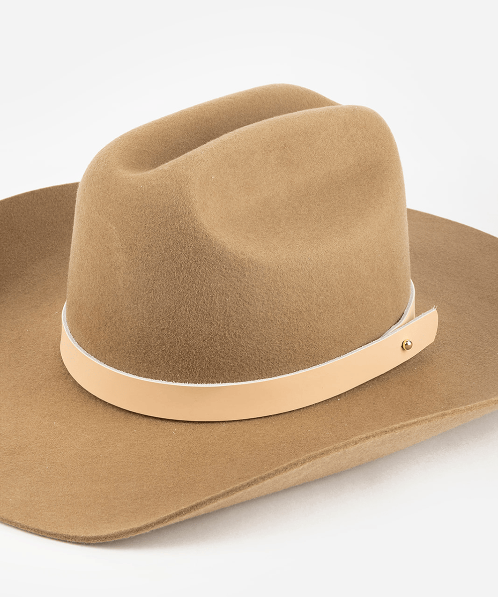 Tan cowboy hat with a nude leather band on a white background #color_nude