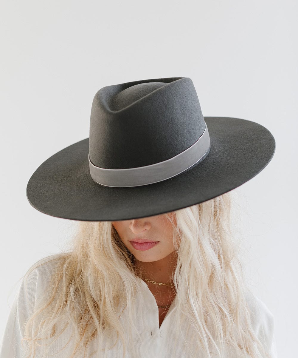 Woman wearing a dark grey hat with a light grey velvet chain hat band against a plain background #color_light grey