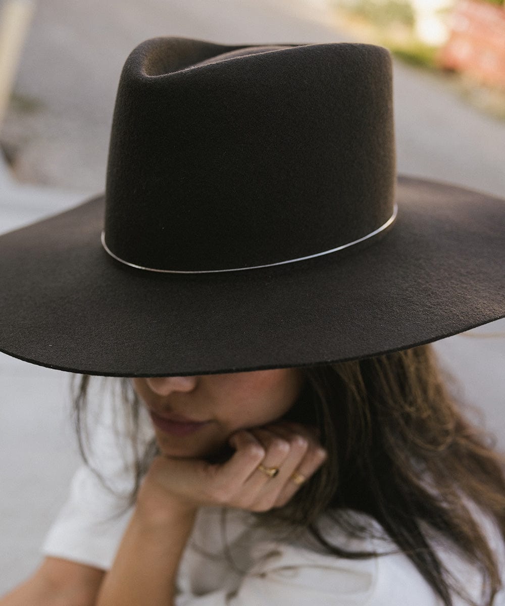 A close-up image of a person wearing a brown hat with a silver chain bolo hat band #color_silver