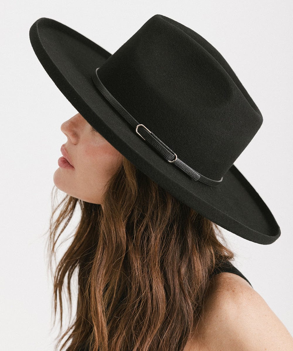 Woman wearing a black wide-brimmed hat with a black hat band, posing sideways against a plain background #color_black