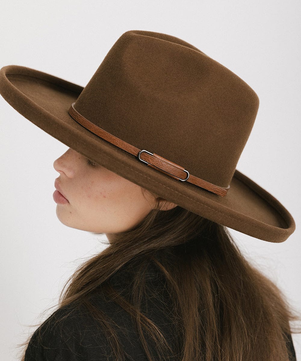 Woman wearing a brown wide-brimmed hat with a brown hat band and a black shirt, facing sideways against a plain background #color_brown