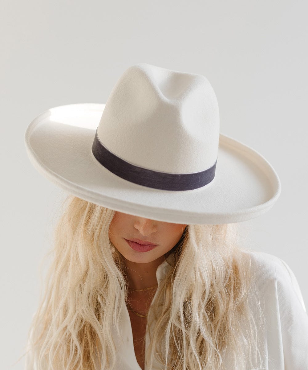 Woman wearing a white hat with a steel blue colored velvet chain hat band against a plain background #color_steel blue