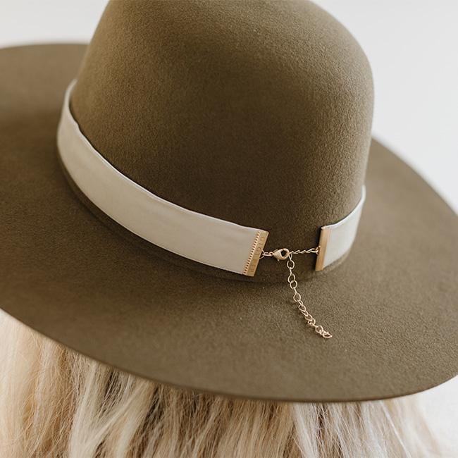 Close up image of a brown hat with a cream velvet chain hat band against a plain background #color_cream