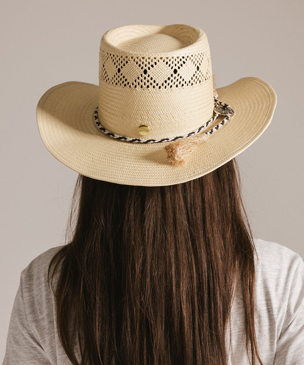 Woman wearing a beige hat with a black and white colored braided bolo tassel hat band and a grey t-shirt, facing behind against a plain background #color_white-black