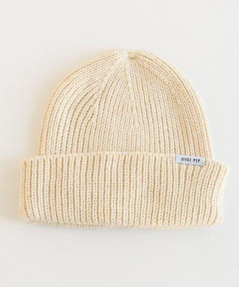 An oatmeal colored knit beanie with the brand label on a white background #color_oatmeal
