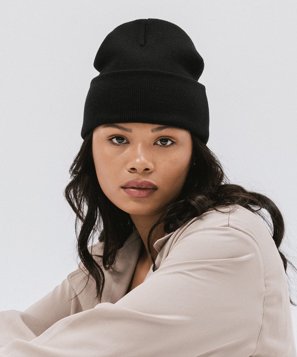 Woman wearing a black beanie and a cream shirt against a plain background #color_black