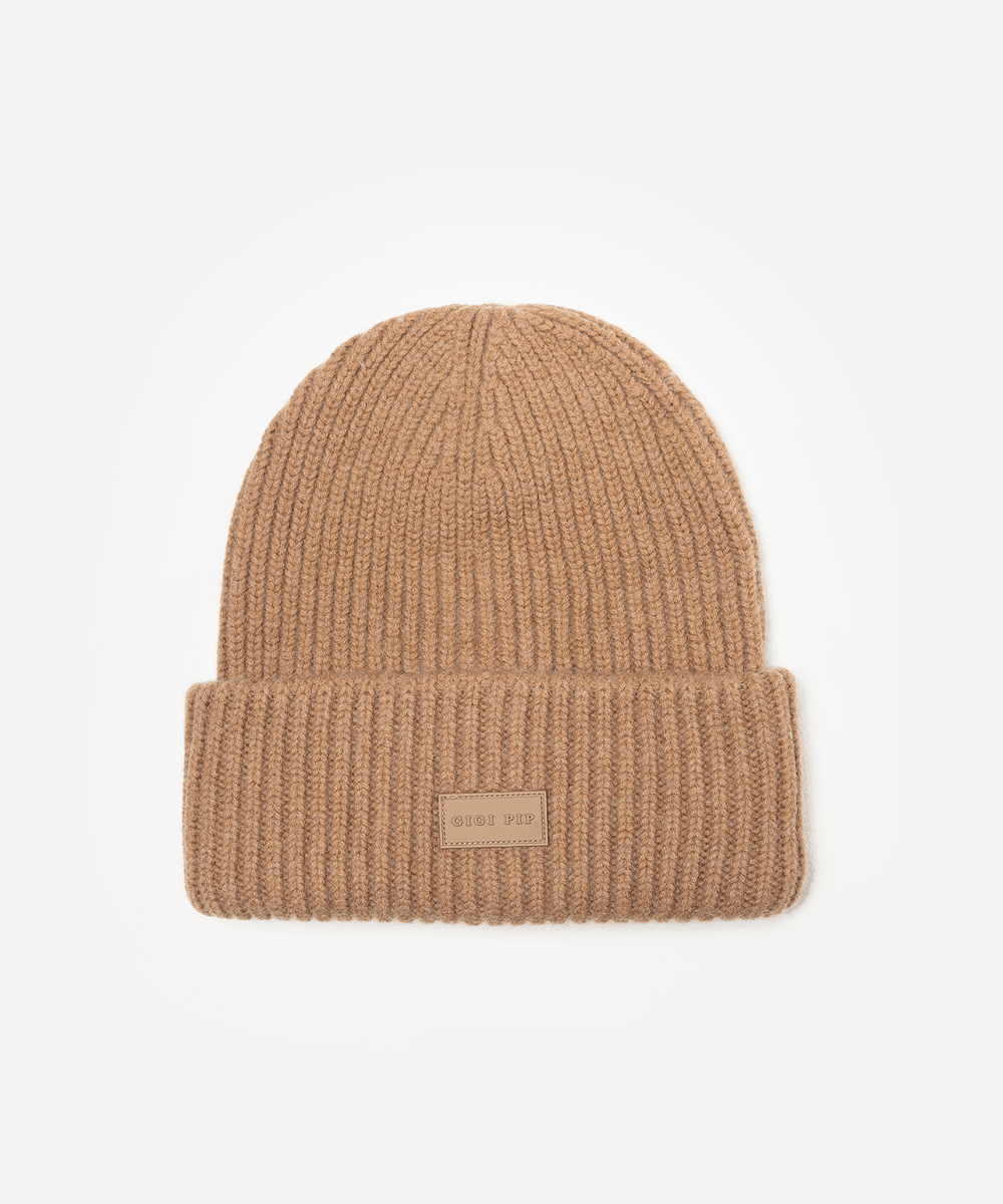 Beige knit beanie with a small label on a white background #color_brown