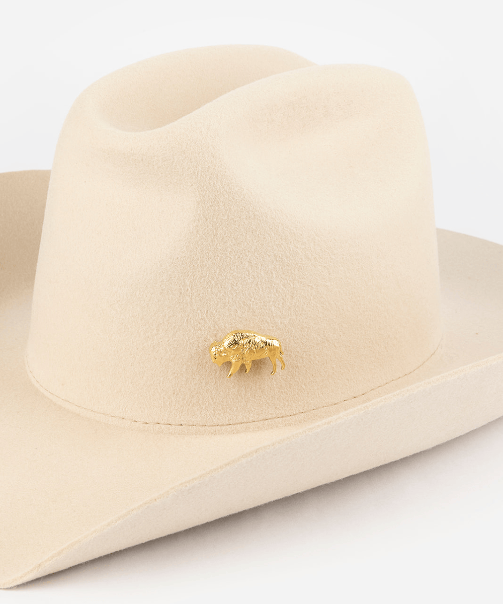 Pink cowboy hat with a gold buffalo-shaped hat pin on a white background #color_gold