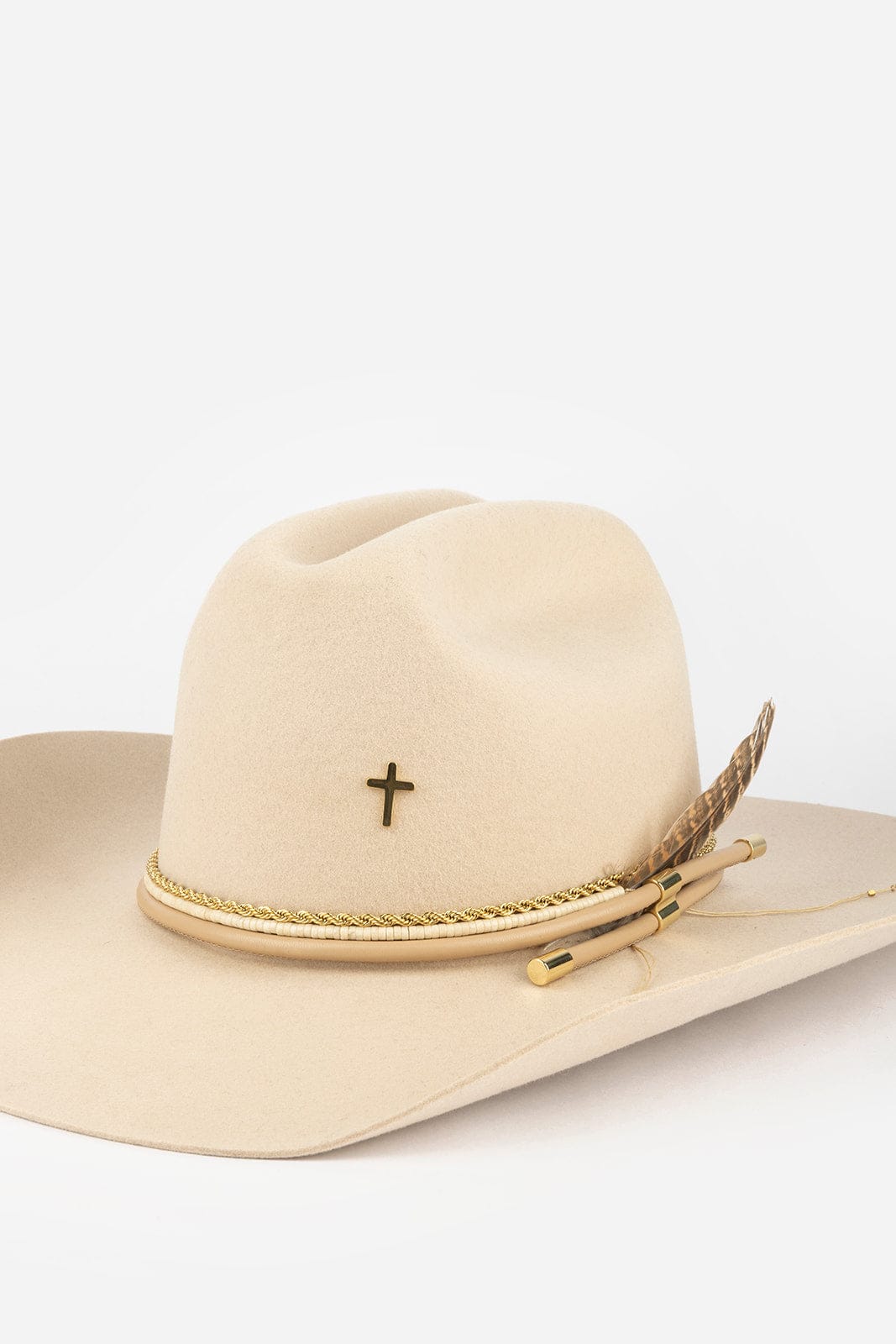 Beige cowboy hat with cross and feather detail on a white background #color_gold