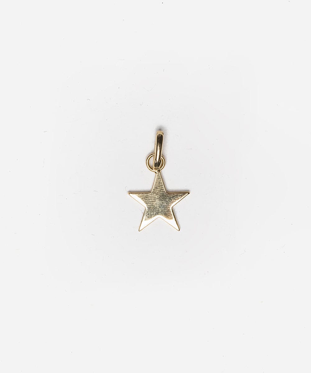 A gold star hat charm on a plain background #color_gold