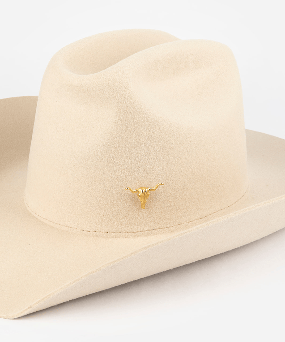 Pink cowboy hat with a gold longhorn-shaped hat pin on a white background #color_gold