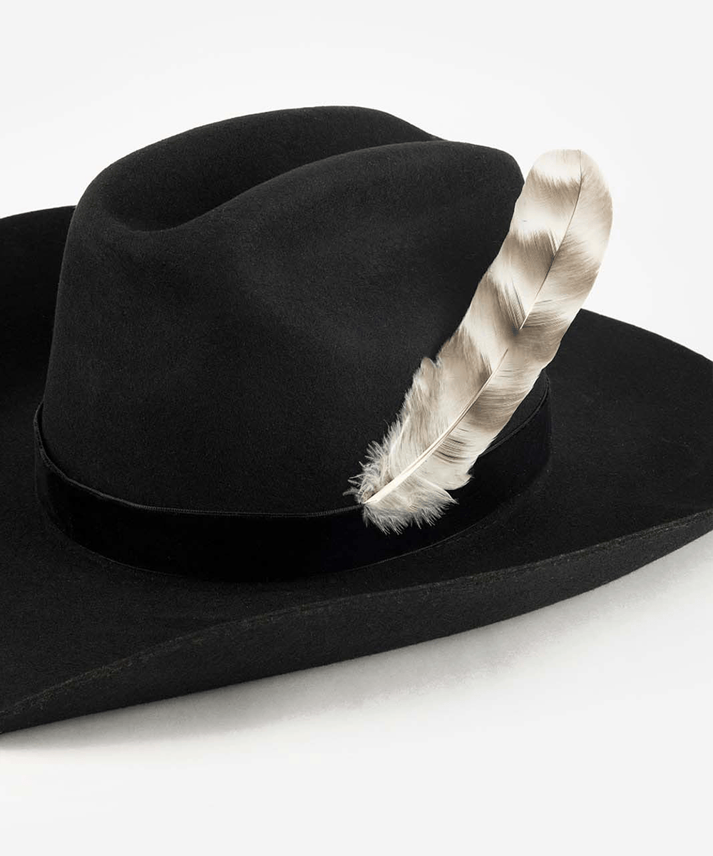 Black fedora hat with a natural grey chinchilla hat feather on a plain background #color_grey