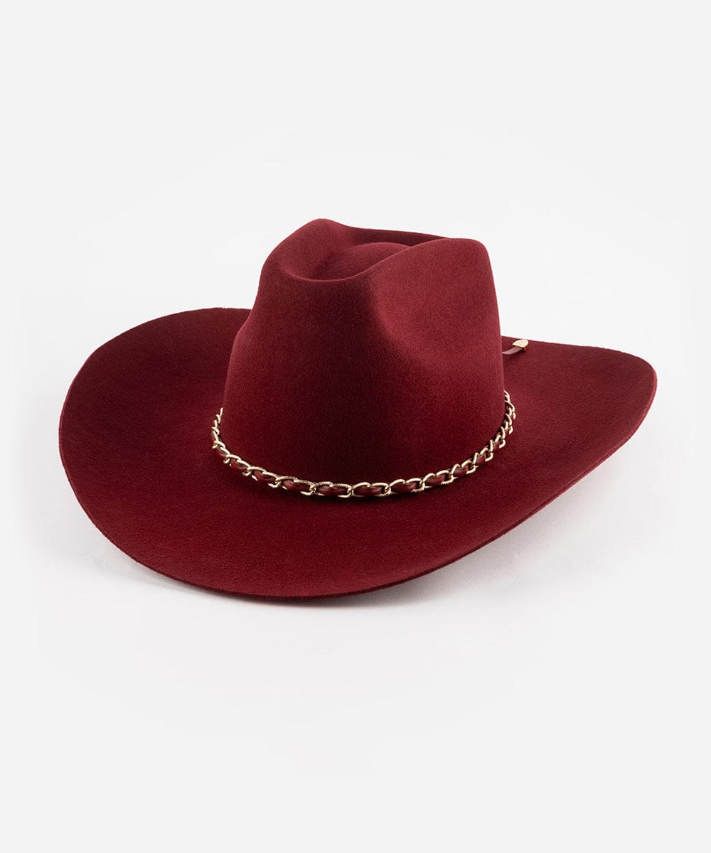 A burgundy colored felt hat with a stiff western brim and a unique hand-shaped brick top crown, featuring a metallic chain detail on the band. #color_burgundy