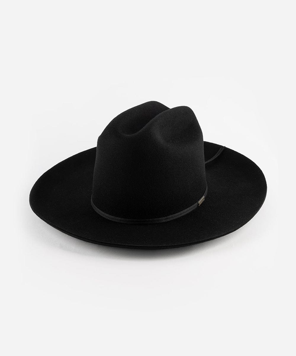 A black Western hat with a classic cattleman crown and an upturned brim. It features a tall crown and a stiff brim with a tonal grosgrain band and a brass Gigi Pip pin. #color_black