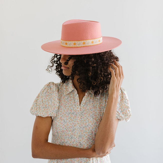 Woman wearing a pink Dakota Dae Triangle Crown hat with a band and a light colored top, facing sideways against a plain background #color_pink