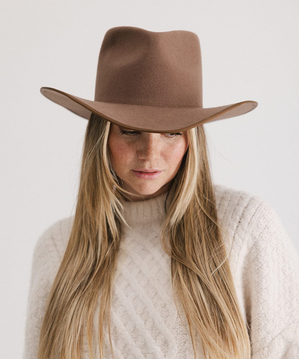 Woman wearing a chocolate brown felt western hat and a cream sweatshirt against a white background #color_chocolate
