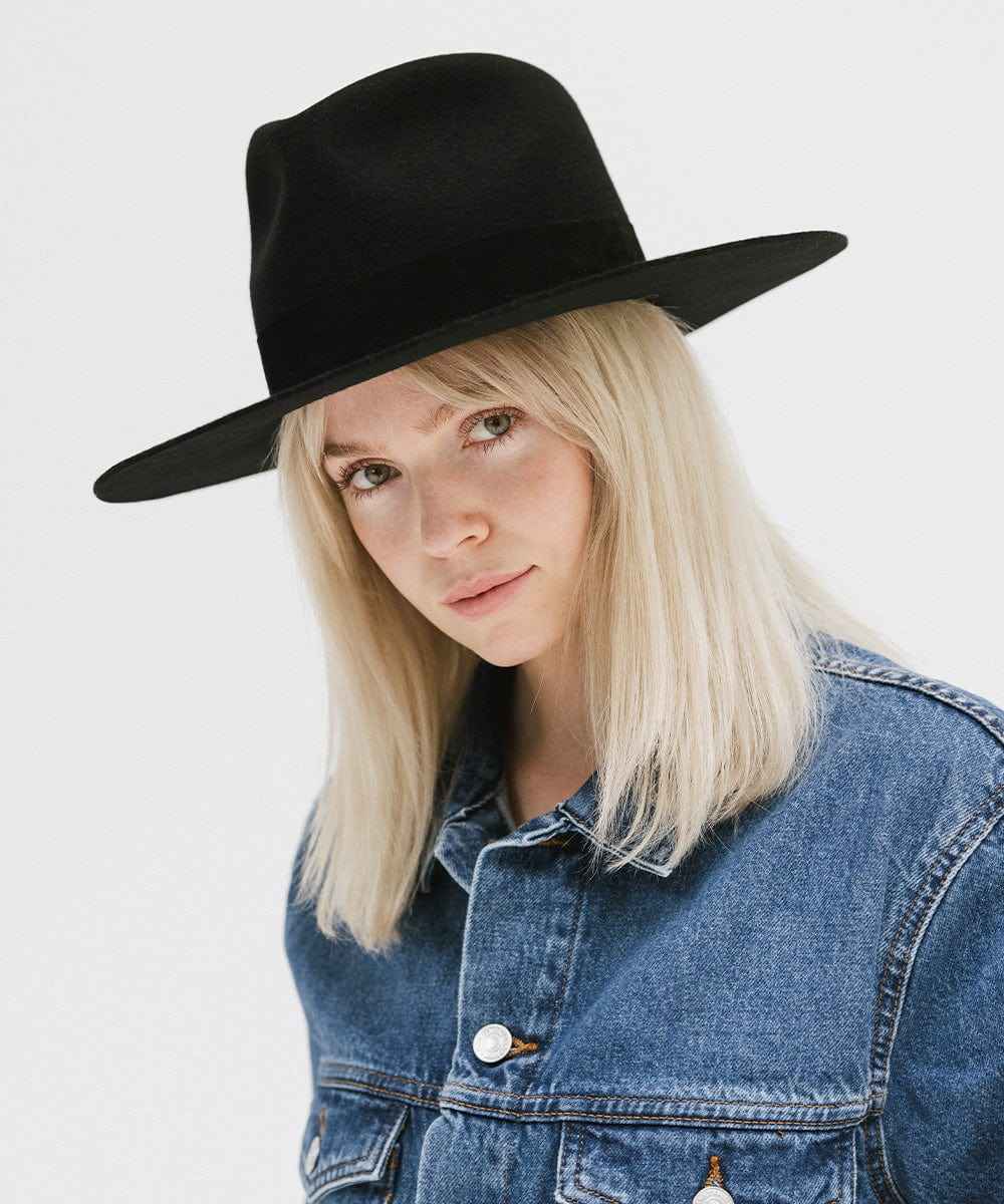 Woman wearing a black hat and denim jacket on a white background #color_black