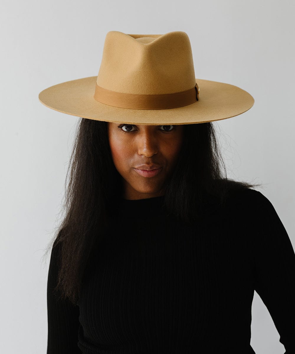 Woman wearing a honeycomb  colored wide brim fedora hat with a band and a black t-shirt against a plain background #color_honeycomb