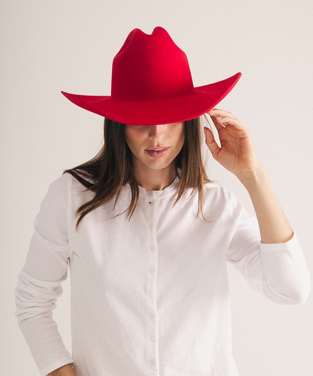 Woman wearing a red hat and white shirt on a light background #color_cherry red