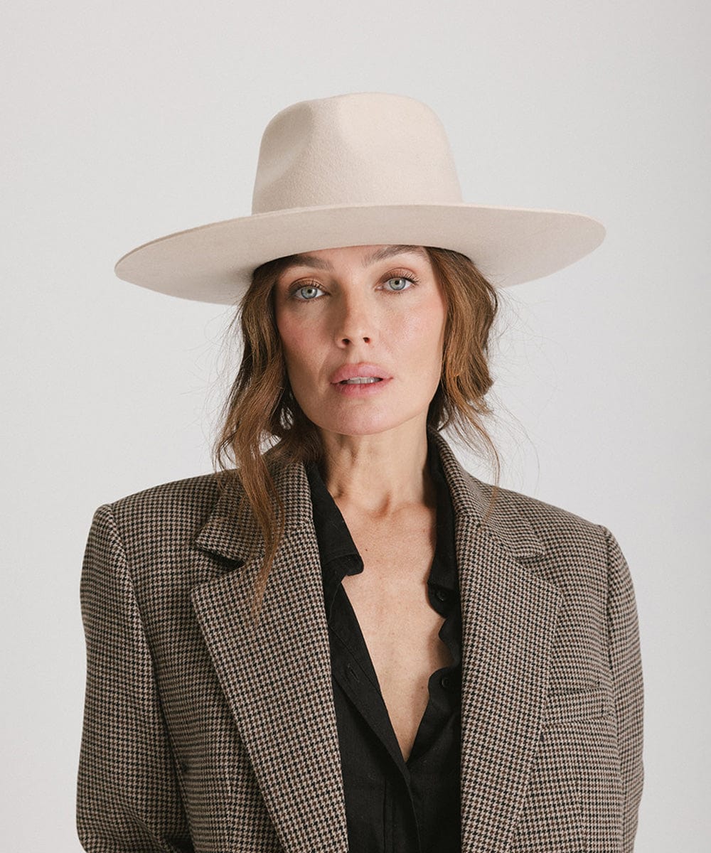 Woman wearing a cream Wesley Wide Brim Fedora Hat and a blazer  against a plain background #color_cream