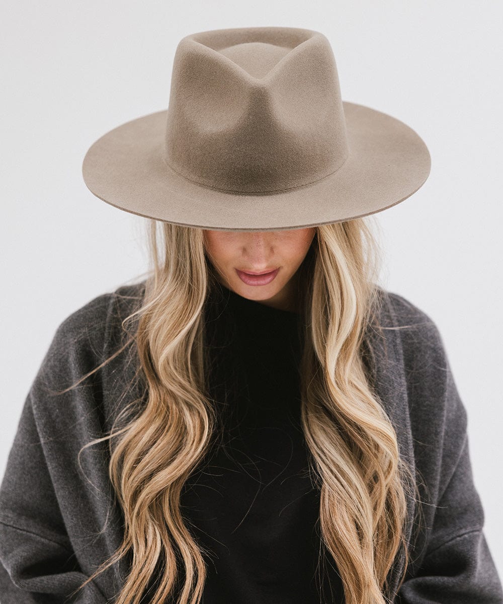 Woman wearing a sage Zephyr Rancher Hat and a dark grey jacket against a white background #color_sage