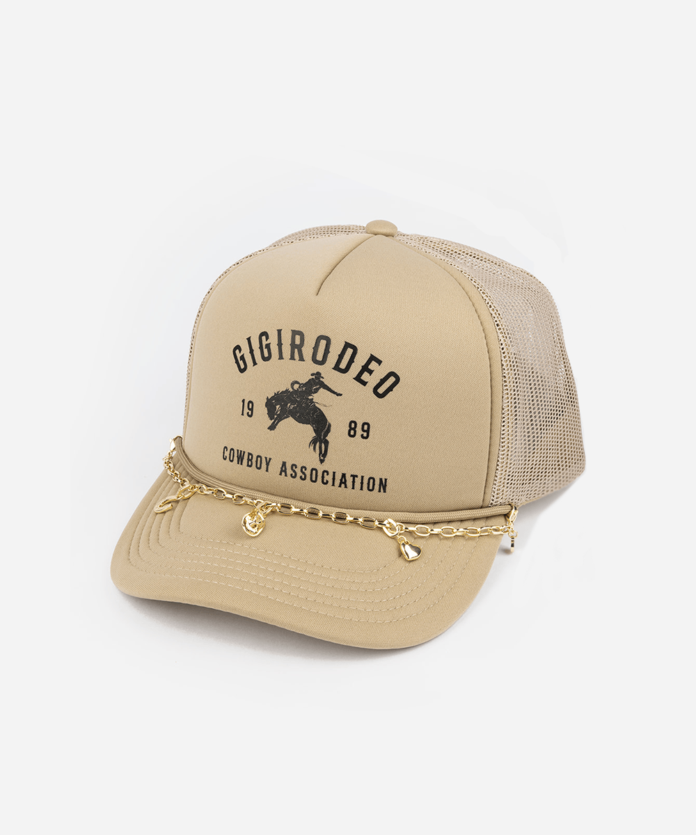 Beige trucker hat with gold chain and 'Gigi Rodeo' branding on a white background #color_gold