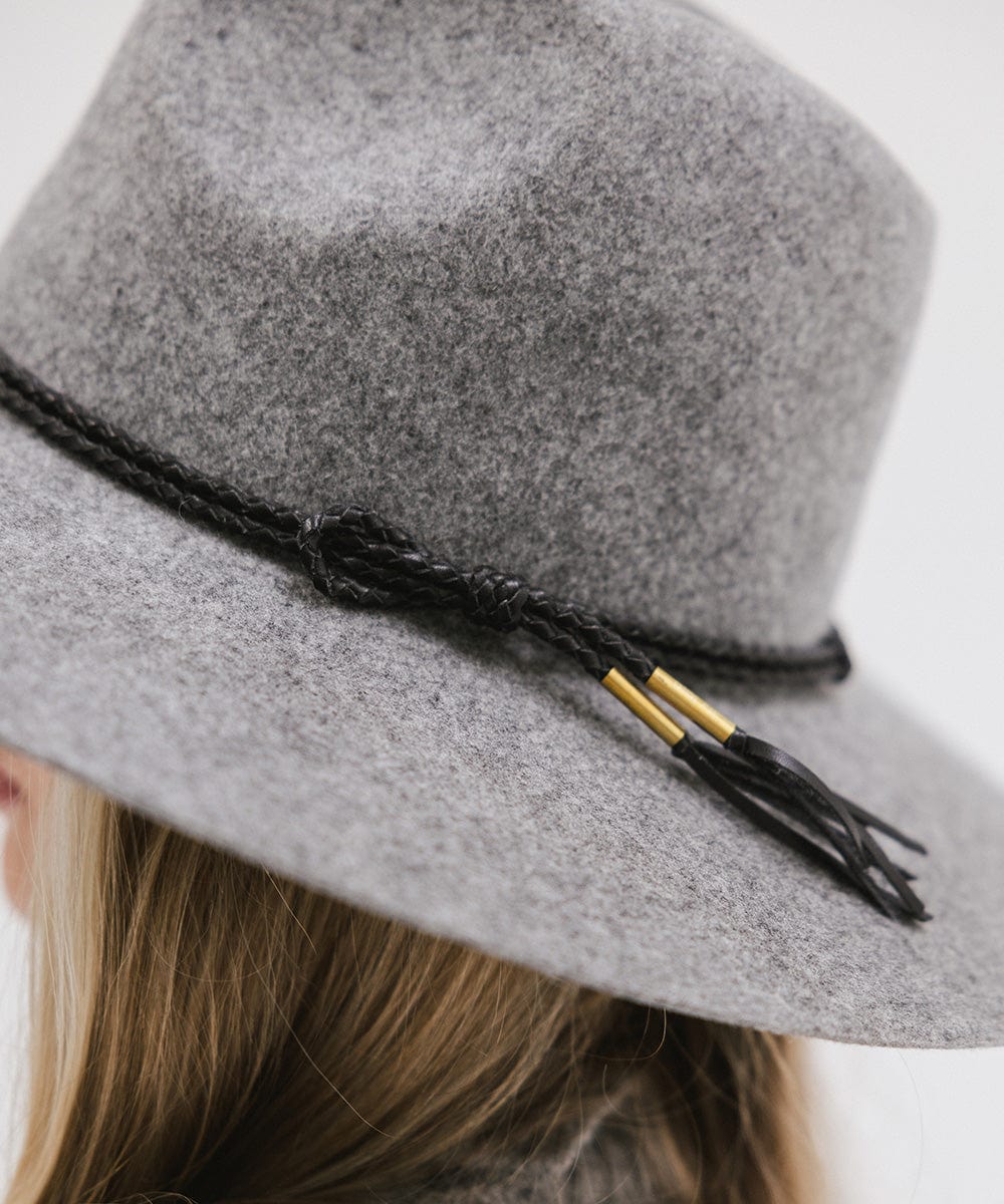 A grey cowboy hat with a black lasso braided hat band against a plain background #color_black