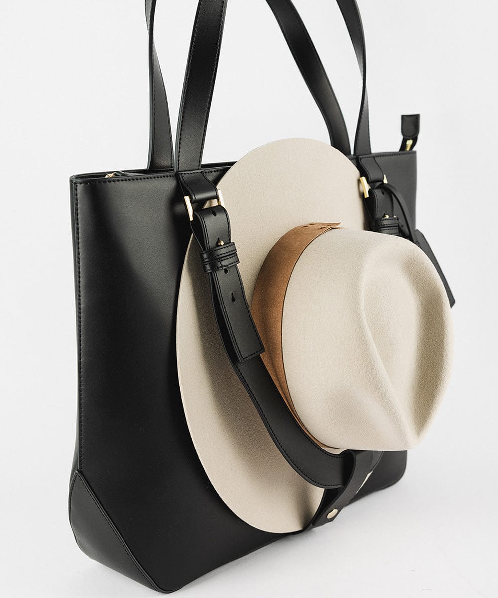 A black Hayes Hat Carrying Tote bag with a cream cowboy hat against a plain background #color_black