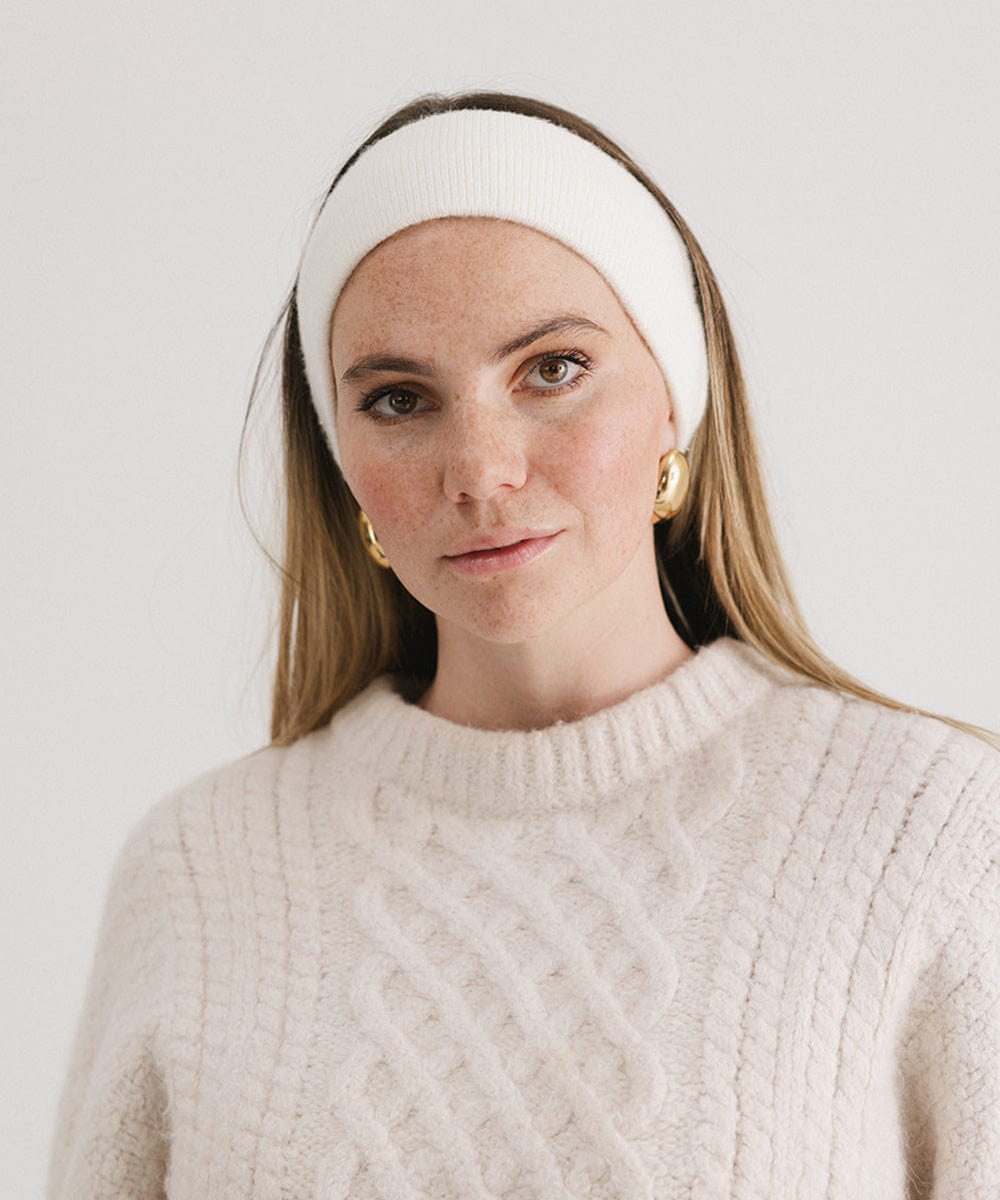 Woman wearing an ivory colored headband and a white sweater against a plain background #color_ivory