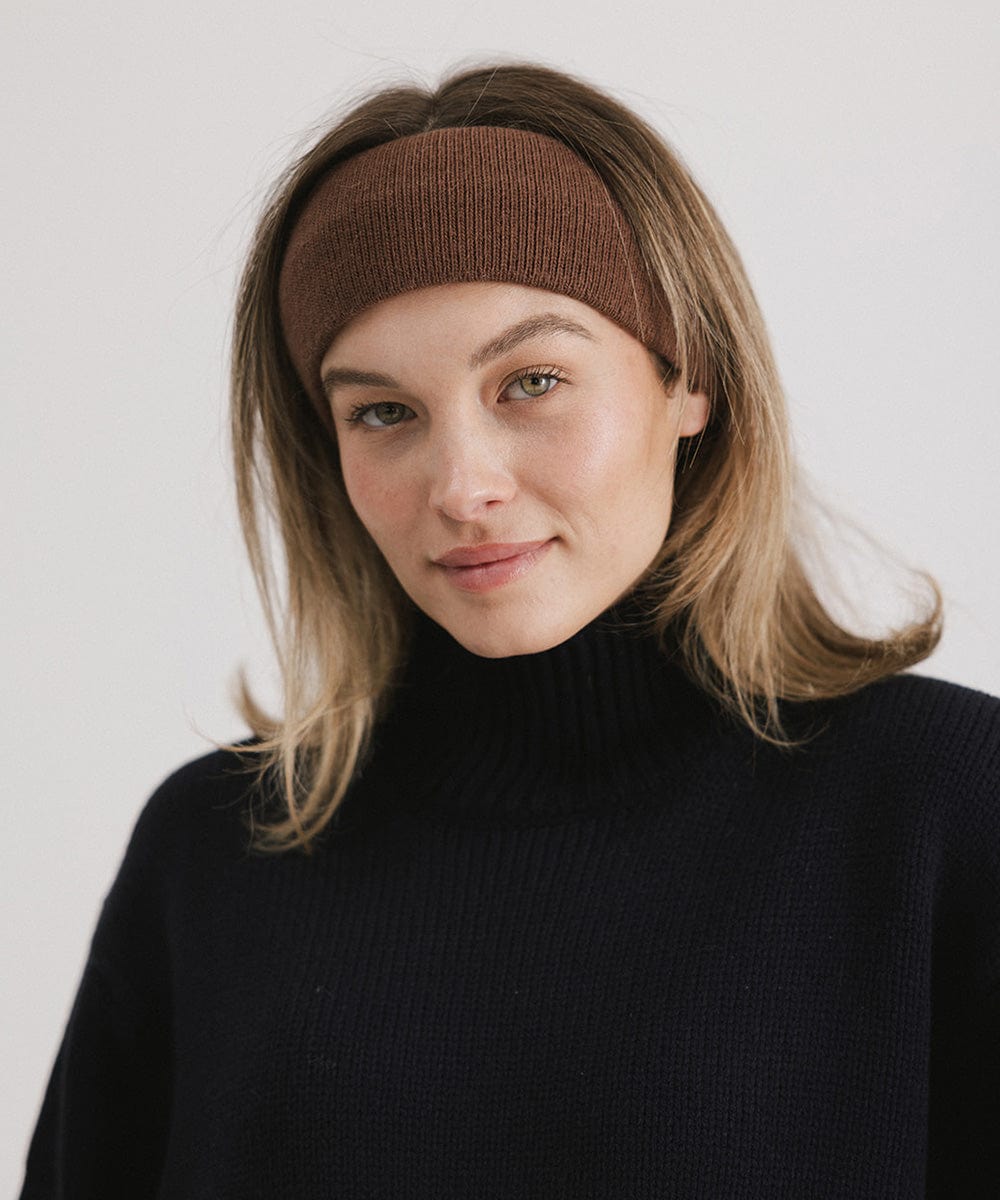 Woman wearing a chocolate colored headband and a black sweater against a plain background #color_chocolate
