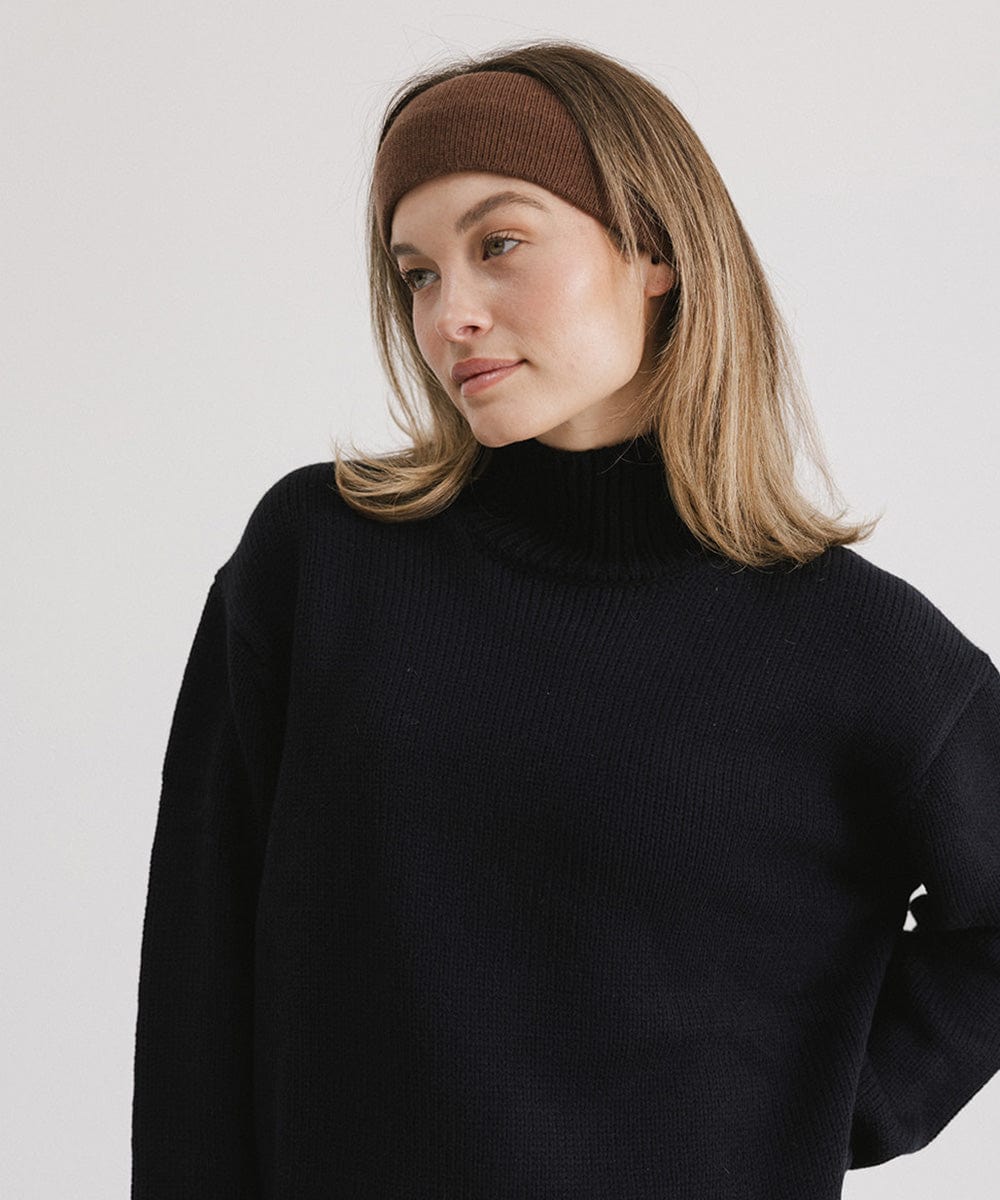 Woman wearing a chocolate colored headband and a black sweater, posing against a plain background #color_chocolate
