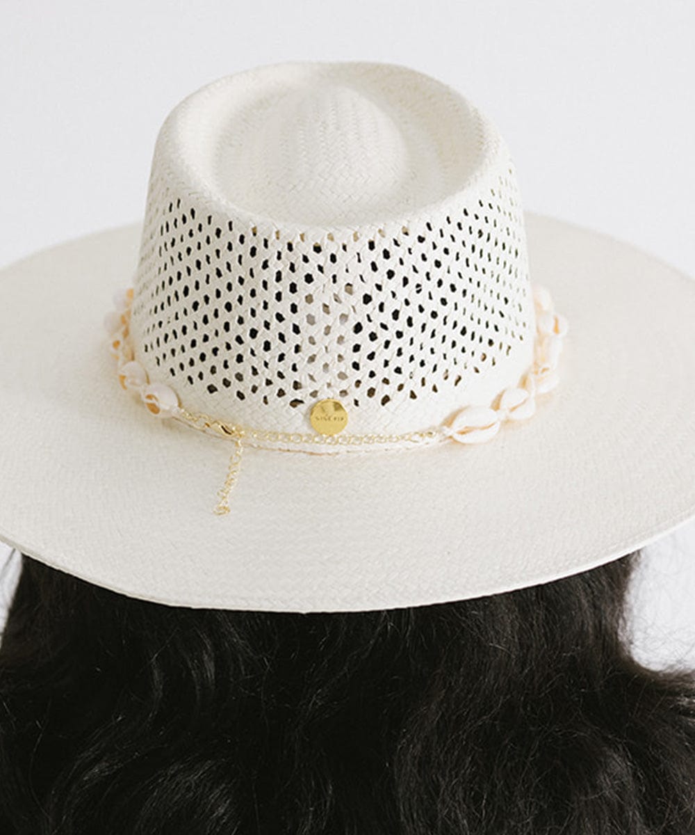 Woman wearing a white hat with a white shell hat band facing behind against a plain background #color_natural