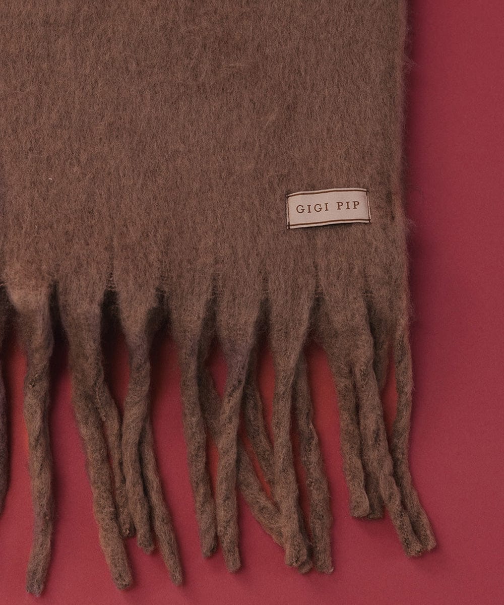 A brown knit scarf with fringes on a red background #color_brown