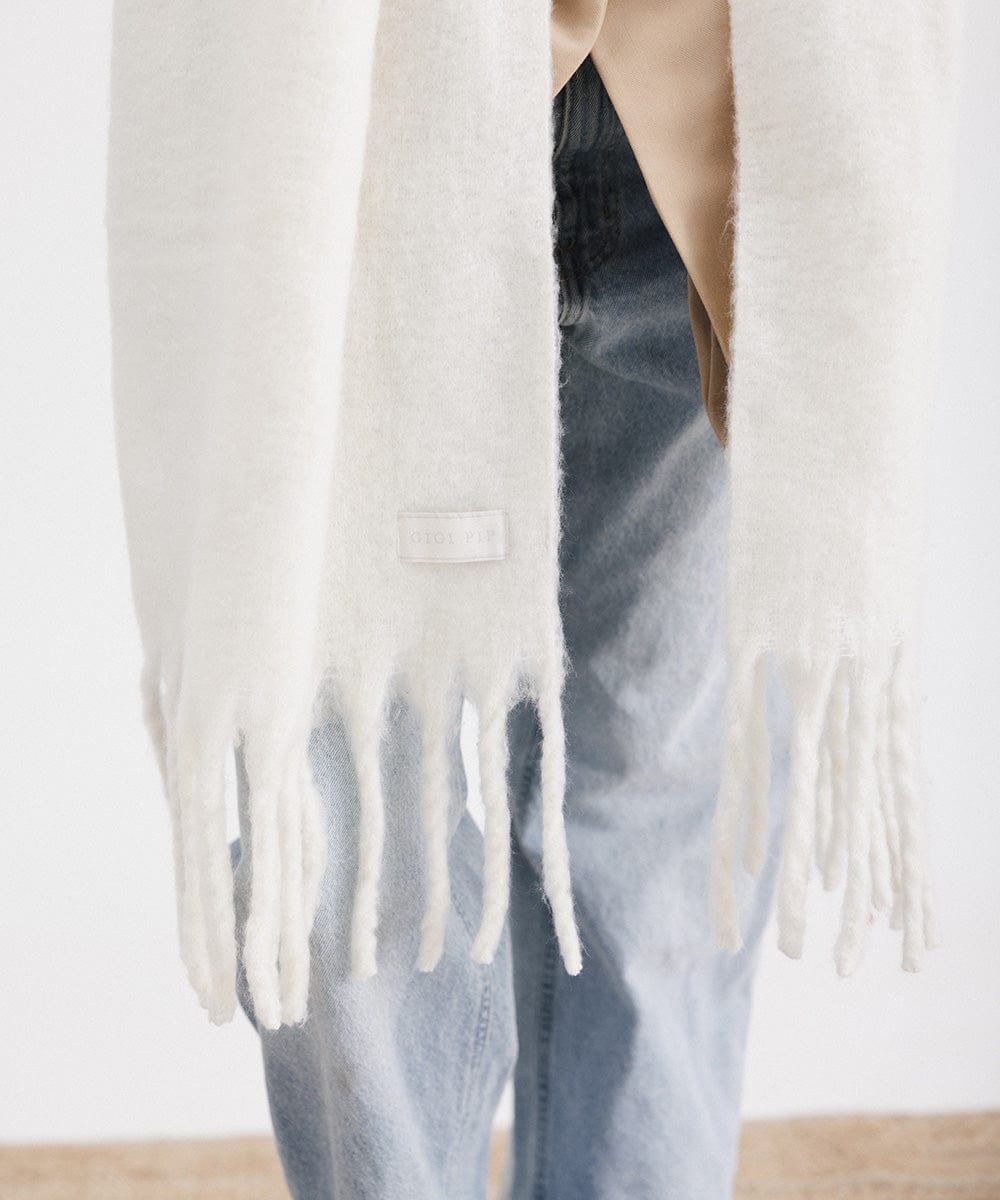 An off white oversized knit scarf with fringes #color_off white