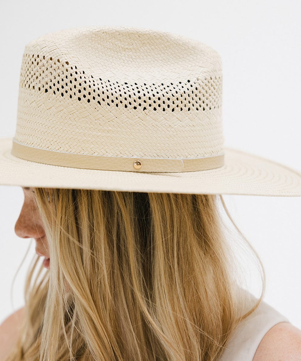 Woman wearing a natural colored straw cowboy hat with a hat band, facing sideways against a plain background  #color_natural
