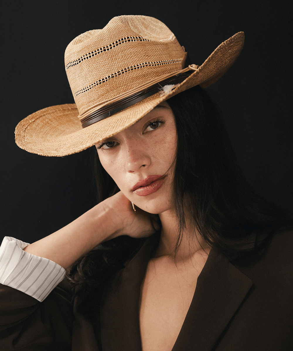 Washed tan colored straw cowboy hat on a woman with a black background #color_washed tan