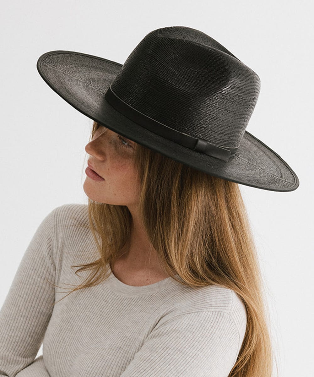 Woman wearing a black wide brim fedora hat with a hat band and a grey t-shirt, facing sideways against a plain background #color_limited edition black