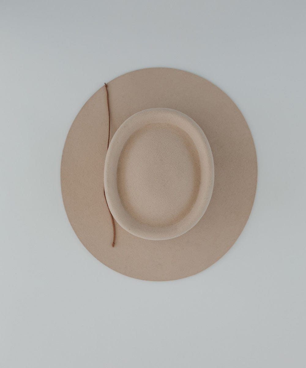 A cream hat with a brown suede band on a plain background #color_brown